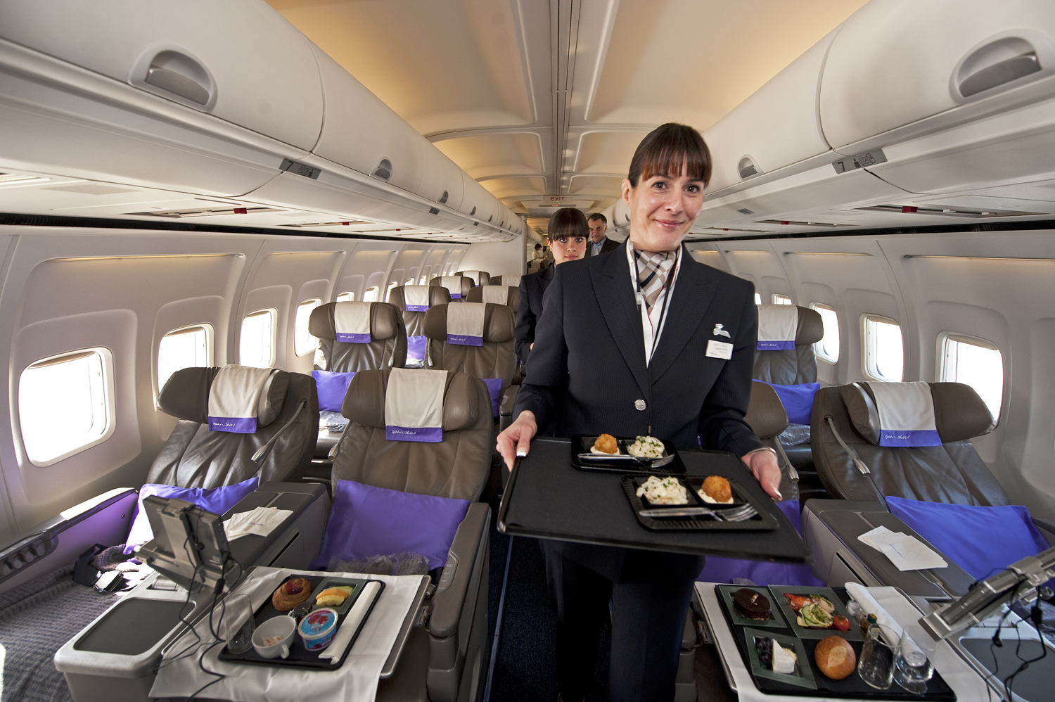 A flight attendant for the new airline Open Skies, a 100 percent business class airline with authentic French cuisine, poses on March 24, 2010 at Washington-Dulles International airport in Virginia. The upscale airline travels from New York and Washington, DC to Paris. AFP Photo/Paul J. Richards (Photo credit should read PAUL J. RICHARDS/AFP/Getty Images)