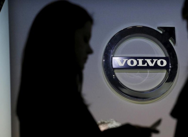 People are seen in silhouette near the Volvo auto stand during the media preview of the 2016 New York International Auto Show in Manhattan, New York