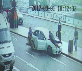 “فيديو” شاهد شرطي مرور صيني يتشبث بغطاء سيارة هاربة لمسافة 2 كم