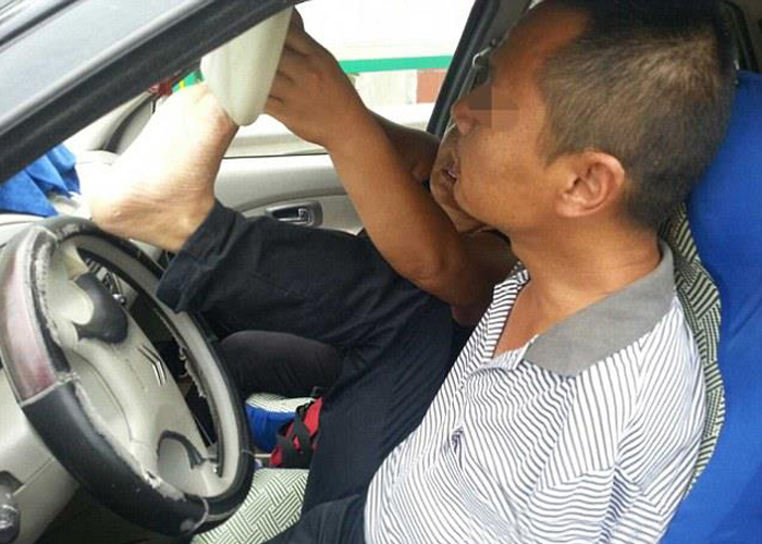 “بالصور” القبض على سائق صيني يقود سيارته بقدميه فقط!